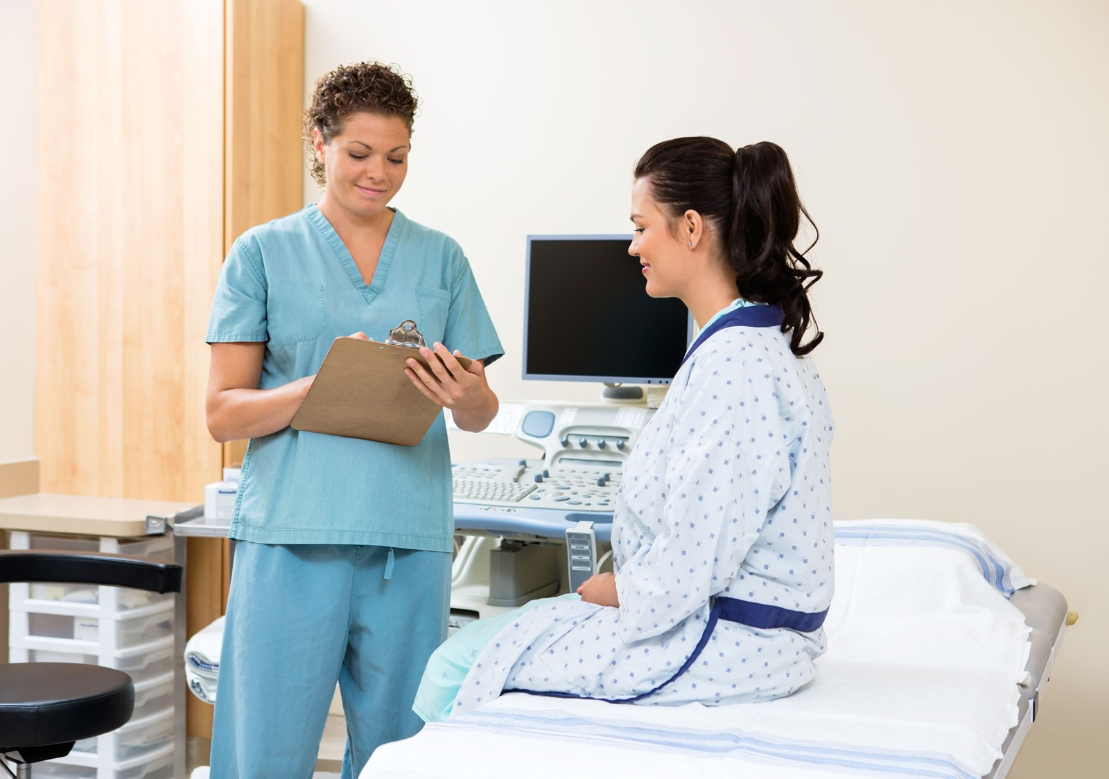 nurse writing notes patient hospital bed